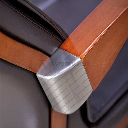 Close-up of a wooden chair armrest with a metal bracket, featuring the brand 'Kantorku. Temukan Kursi Kerja Pimpinan kamu hanya Di kantorku.co.id Solusi Tepat Kebutuhan Kantor Kamu!!